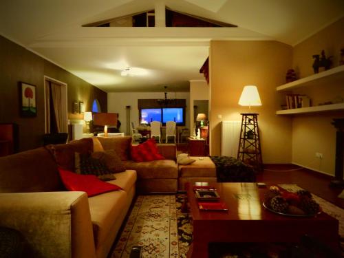 a living room with a couch and a table at Villa Vravrona Tower & Suites in Markopoulo