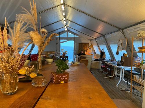 a long wooden table in a tent with a view of the ocean at Aparra Surfcamp Hendaye in Hendaye