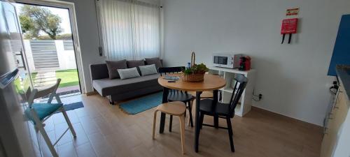 a small kitchen and living room with a table and chairs at Casa 37 - Country Home in Terrugem