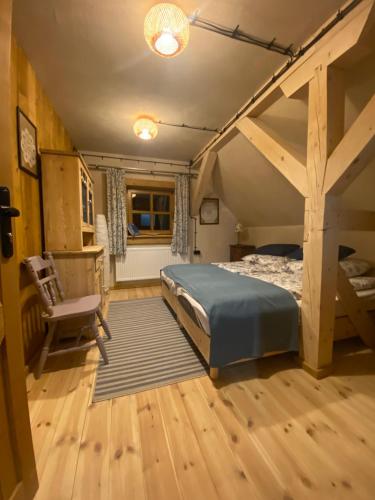 ein Schlafzimmer mit einem Bett und einem Stuhl in einem Zimmer in der Unterkunft Chyża Hapełe in Zatwarnica