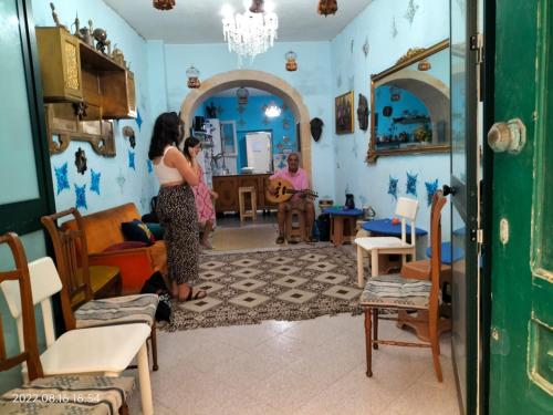 twee vrouwen in een woonkamer met een kind bij Casa dei fiori in Siracusa