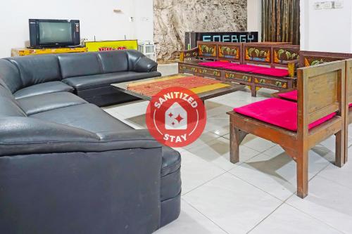 un soggiorno con divano, tavoli e TV di OYO LIfe 91571 Hotel Ss Bukit Cemara Syariah a Batu
