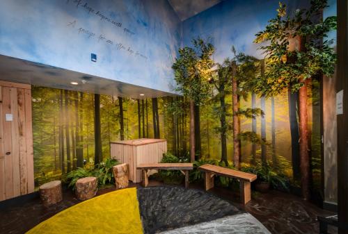 a room with a forest mural on the wall at Skwachàys Lodge in Vancouver