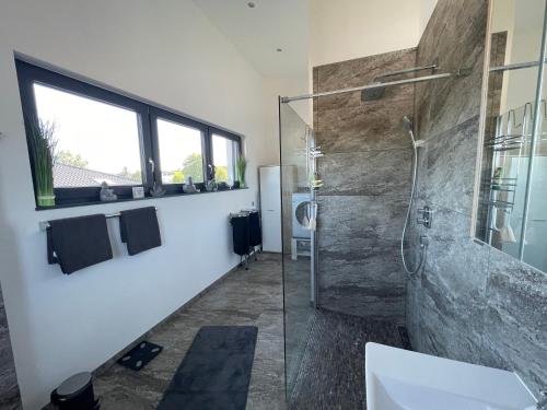 bagno con doccia e porta in vetro di #NEU l Seeblick l NETFLIX l BOXSPRING l NESPRESSO l e-TÜR l Terrasse l 82m2 a Ulmen