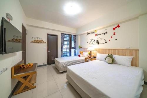 a hotel room with two beds and a television at 礁溪幸福民宿Jiaoxi Happy Homestay in Jiaoxi