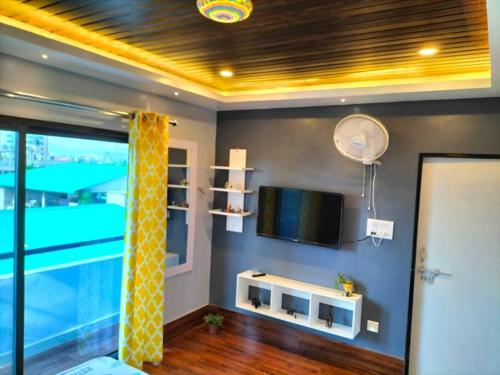 a living room with a tv and a swimming pool at Terrace Cottage Garden Homestay at Guwahati in Guwahati