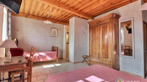 a bedroom with a bed and a desk in a room at Domaine du Clap in Pranles