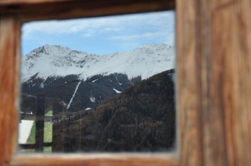 a view of a snow covered mountain through a window at Panorama Chalet Heimatliebe in Ladis
