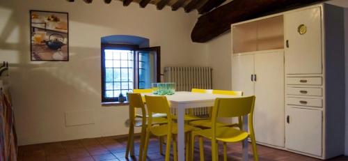 a kitchen with a white table and yellow chairs at Country Home Lonato in Lonato del Garda
