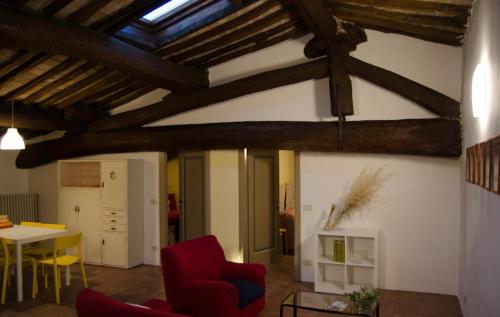 a living room with a red chair and a table at Country Home Lonato in Lonato del Garda