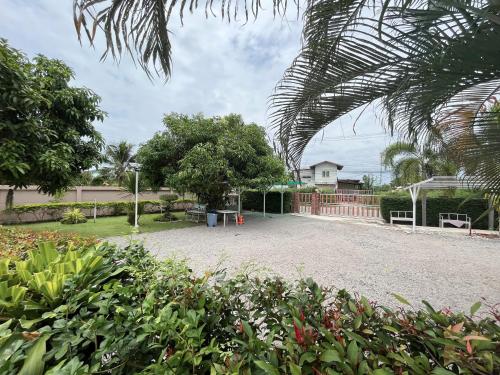 a large gravel driveway in front of a house at Home JANO in Cha Am