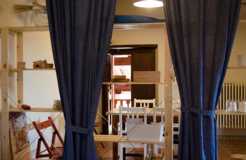 two blue curtains in a room with a table and chairs at Country Home Lonato in Lonato del Garda