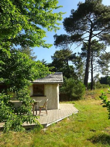 une cabine avec une table et une chaise sur une terrasse dans l'établissement maisonnette écologique isolée en botte de paille, à Ploërmel