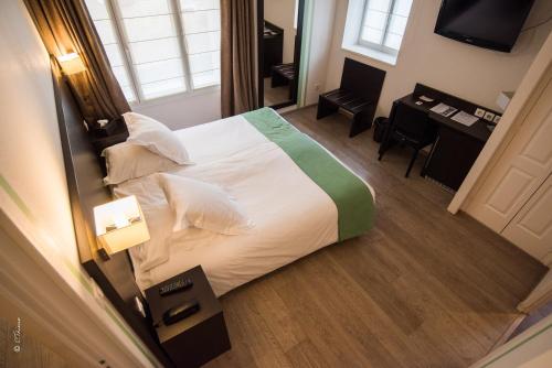 a hotel room with a large bed and a desk at La Rose in Juliénas