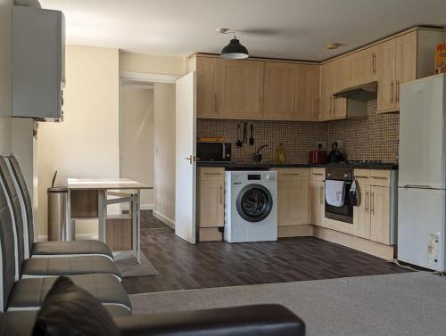 a kitchen with a washer and dryer in a room at Peckhamsbest Suite in London