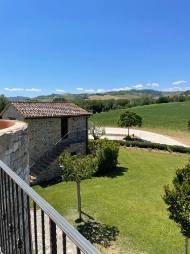a view from the balcony of a house with a yard at Ca' Virginia Country House Wellness in Montecalvo in Foglia