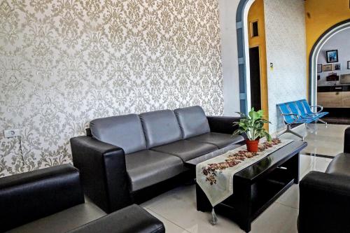 a living room with a couch and blue chairs at Wisma Barokah in Tebingtinggi