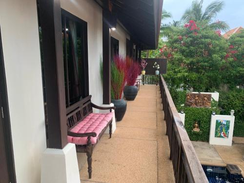 a row of benches sitting on a porch at Samui Dreams Seaview Villa - Bangrak Beach - with Private Pool in Koh Samui 