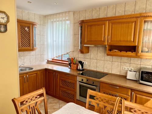 a kitchen with wooden cabinets and a counter top at Gedimino Apartamentai in Juodkrantė