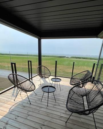 a group of chairs and tables on a porch at MARINIS Luxury Apartments - Svencelės Vėjai - 1st line by the Lagoon in Svenele