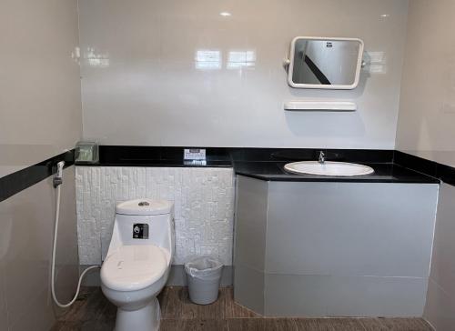 a small bathroom with a toilet and a sink at Home JANO in Cha Am