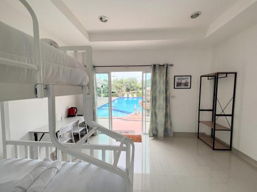 een slaapkamer met een stapelbed en een zwembad bij Home JANO in Cha Am