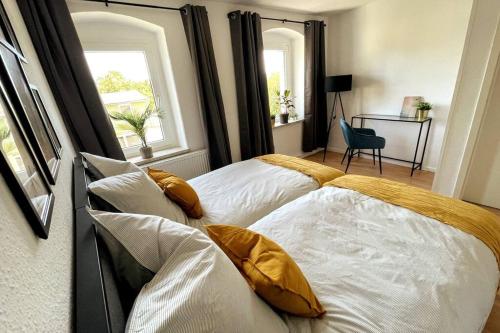 two beds in a bedroom with two windows at Modern 4 Zi Rooms Netflix, Wifi, Parken CasaLuna85 in Flöha
