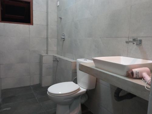 uma casa de banho com um WC branco e um lavatório. em Ridmi Home Stay em Karagampitiya