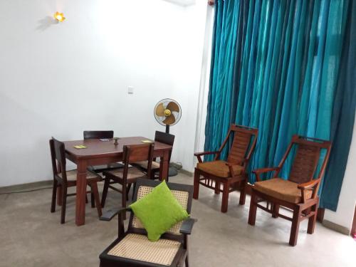 uma sala de jantar com mesa e cadeiras em Ridmi Home Stay em Karagampitiya