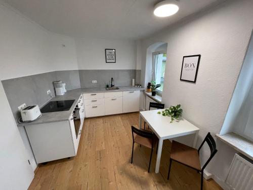 une cuisine avec un évier et une table avec des chaises dans l'établissement Modern 4 Zi Rooms Netflix, Wifi, Parken CasaLuna85, à Flöha