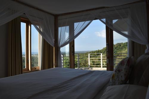 a bedroom with a white bed with a view at Villa Reva Bali in Temukus