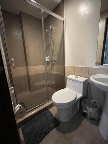 a bathroom with a shower and a toilet and a sink at Luxury suite across SM Megamall in Manila