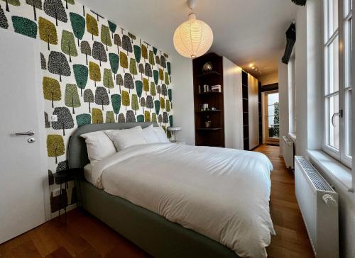 sypialnia z dużym łóżkiem w pokoju ze ścianą w obiekcie Centre ville Haguenau - 5pers w mieście Haguenau