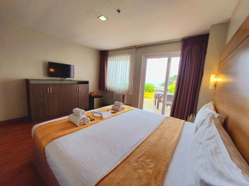 a bedroom with a large bed with two teddy bears on it at Tagaytay Hotel SixB in Tagaytay