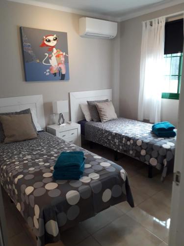 a small bedroom with two beds and a window at Departamento Ingrid in Puerto del Carmen
