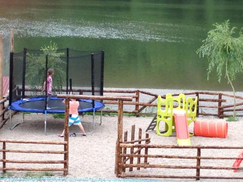 two children playing on a playground next to the water at Hotel Class in Brezoi