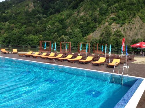 a swimming pool with yellow chairs and a swimming pool at Hotel Class in Brezoi
