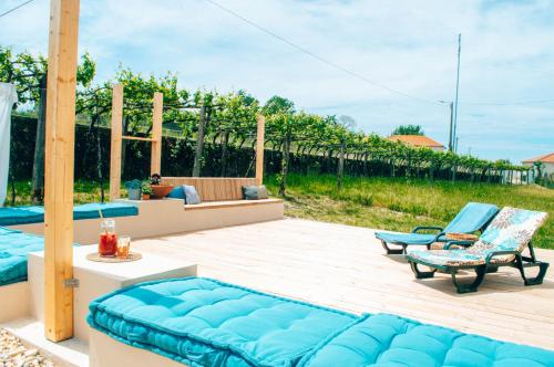 une terrasse avec un canapé bleu et deux chaises dans l'établissement Just Like Home - Casa Antonio em Paredes de Coura, à Paredes de Coura