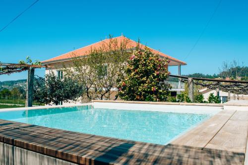 a swimming pool in front of a house at Just Like Home - Casa Antonio em Paredes de Coura in Paredes de Coura