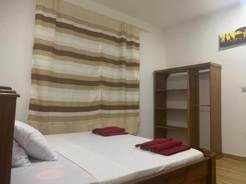 a bedroom with a bed with two red towels on it at villa liam kiwengwa zanzibar in Kiwengwa
