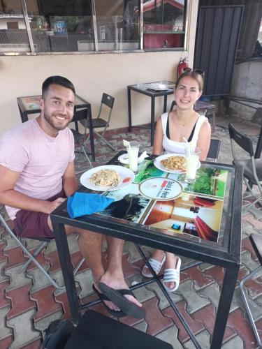 a man and woman sitting at a table with plates of food at Spice & Herb Rooms & Food in Kandy