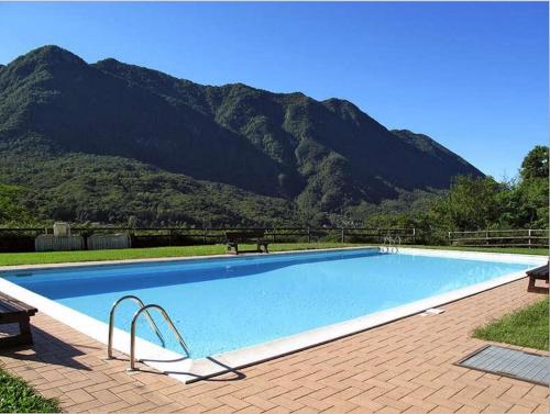 una gran piscina con una montaña en el fondo en Residenza La Rocca, en Castello Valsolda