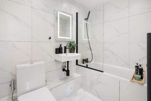 a white bathroom with a sink and a shower at Luxury Majestic Apartment in Marylebone in London