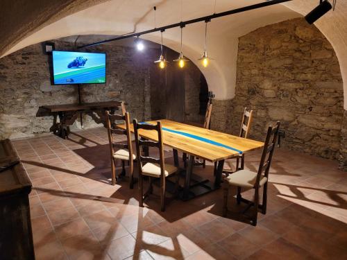 a dining room with a wooden table and a flat screen tv at Ferienwohnungen Appartementhaus Hohe Tauern in Obervellach