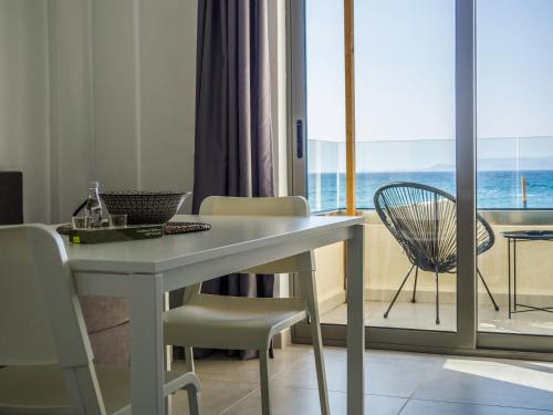een kamer met een tafel met een laptop en een balkon bij Anfi Suites in Gouves