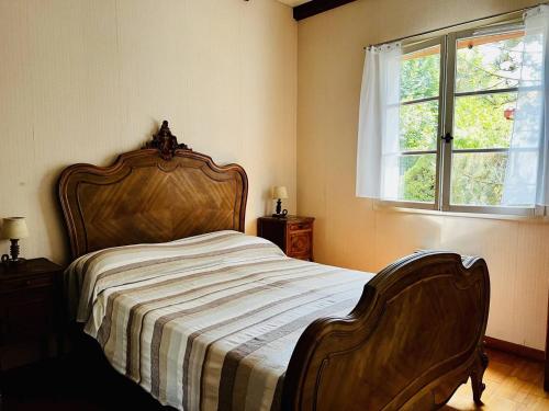 um quarto com uma cama com uma cabeceira em madeira e uma janela em Maison Espelette, 4 pièces, 5 personnes - FR-1-495-2 em Espelette