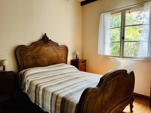 - une chambre avec un lit doté d'une tête de lit en bois et d'une fenêtre dans l'établissement Maison Espelette, 4 pièces, 5 personnes - FR-1-495-2, à Espelette