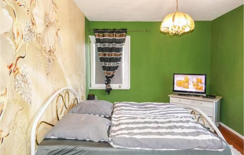 Dormitorio verde con cama y ventana en Gorgeous Home In Kalbe- Milde -kakerbec With Kitchen 