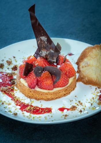 a dessert with strawberries and chocolate on a plate at Hôtel Causse Comtal Rodez, The Originals Relais in Gages-le-Haut