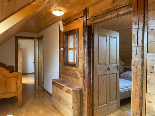Guesthouse Novak في Dvor: غرفة خشبية فيها باب وسرير